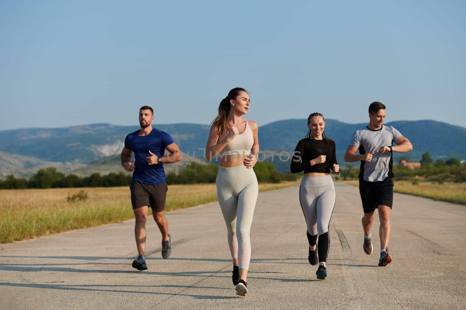 A group of friends maintains a healthy lifestyle by running outdoors on a sunny day, bonding over fitness and enjoying the energizing effects of exercise and nature.