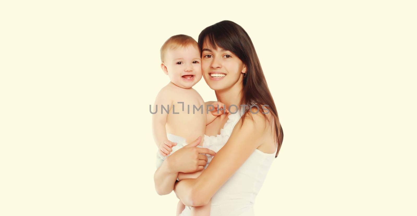 Happy cheerful smiling young mother holding baby on white studio background