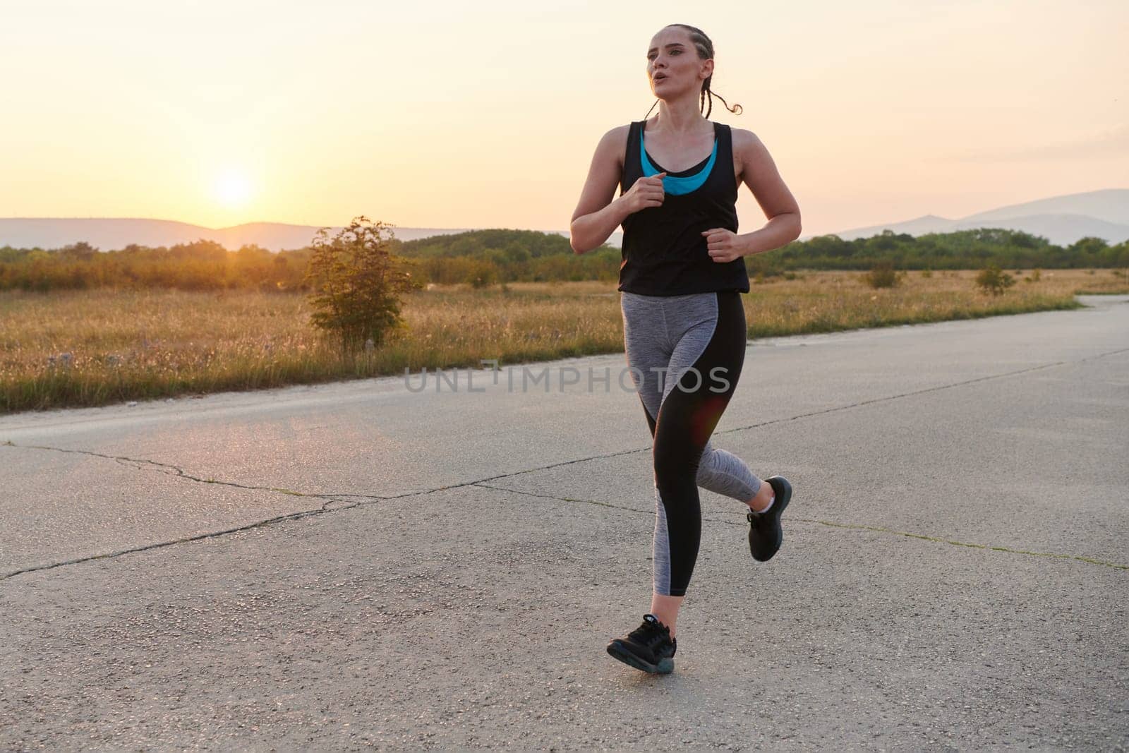 Solo Stride: Determined Athlete Woman Embarks on Fitness Journey for Marathon Preparation. by dotshock