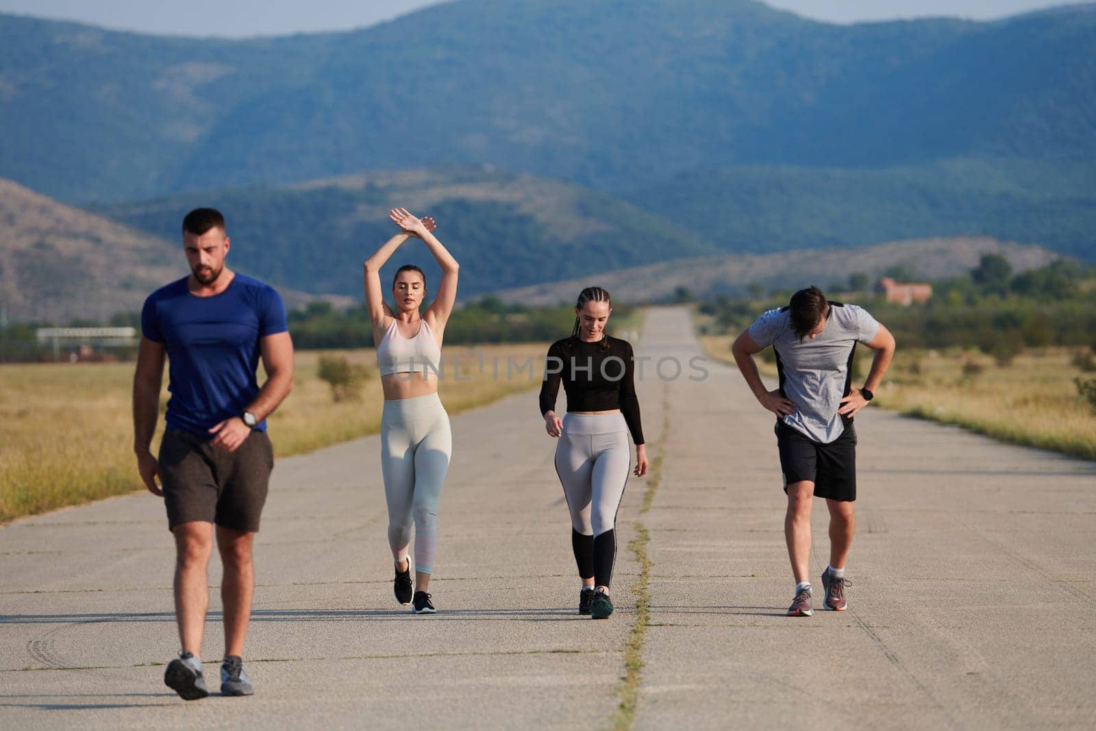 A group of friends maintains a healthy lifestyle by running outdoors on a sunny day, bonding over fitness and enjoying the energizing effects of exercise and nature by dotshock