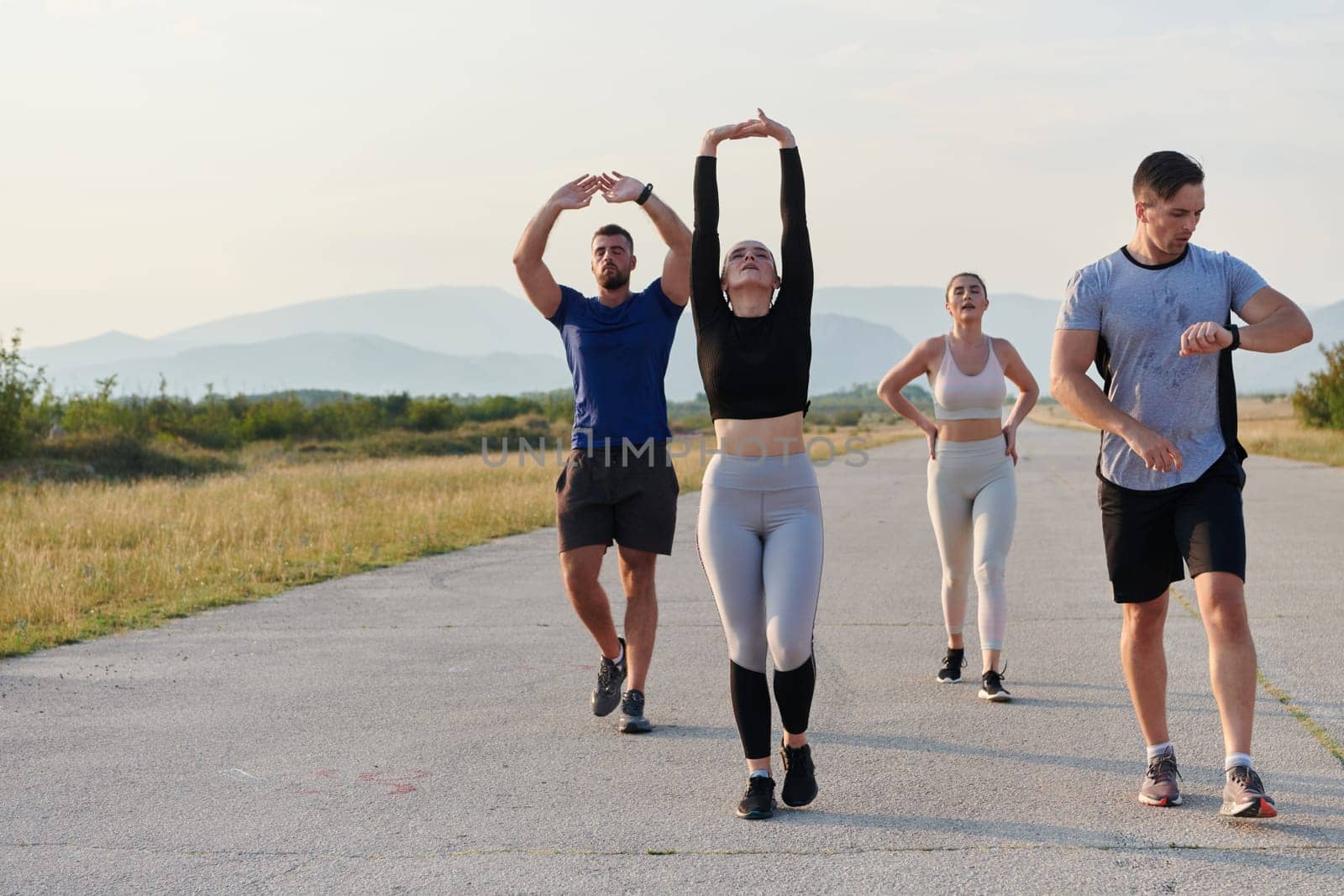 A group of friends maintains a healthy lifestyle by running outdoors on a sunny day, bonding over fitness and enjoying the energizing effects of exercise and nature by dotshock