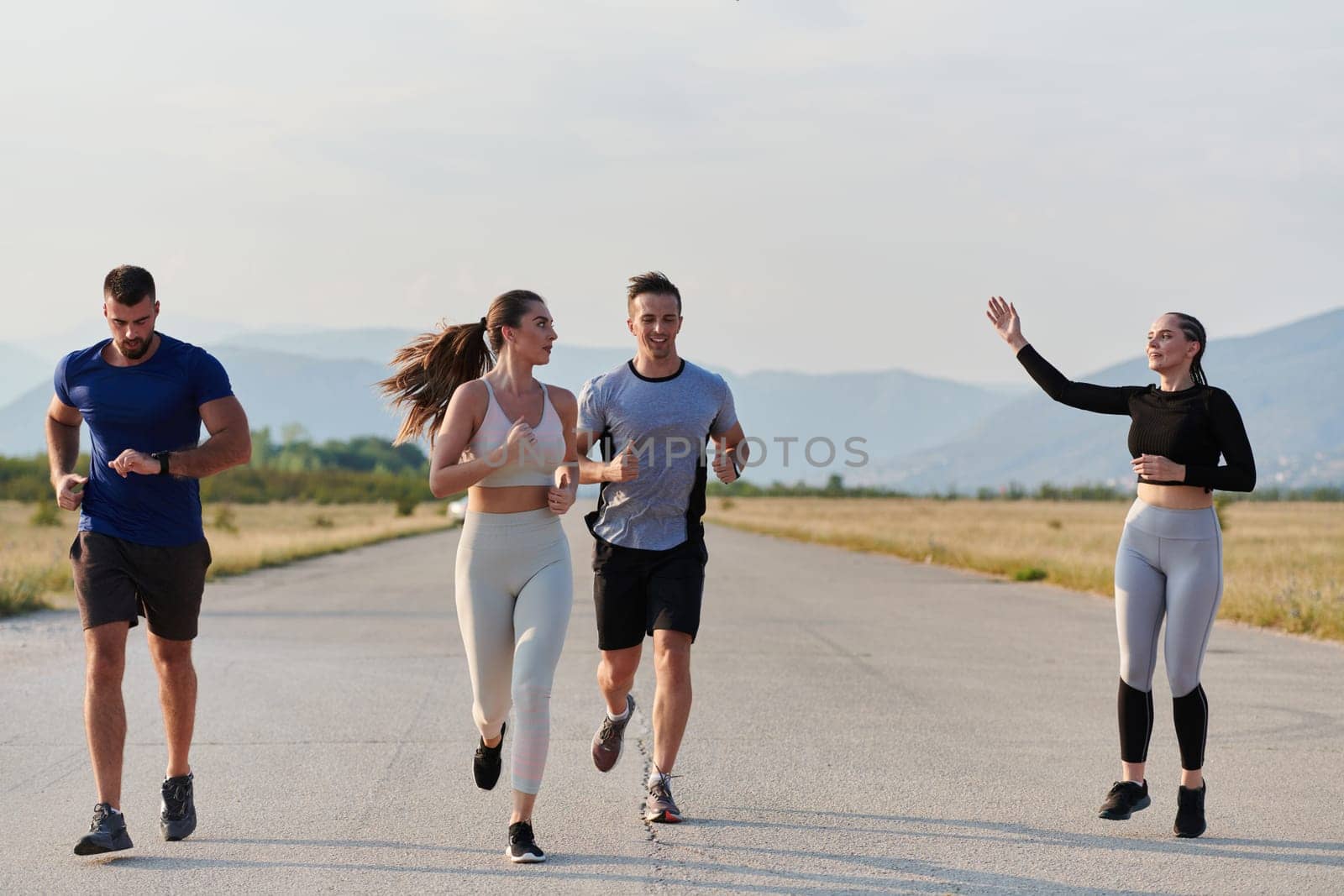 A group of friends maintains a healthy lifestyle by running outdoors on a sunny day, bonding over fitness and enjoying the energizing effects of exercise and nature by dotshock