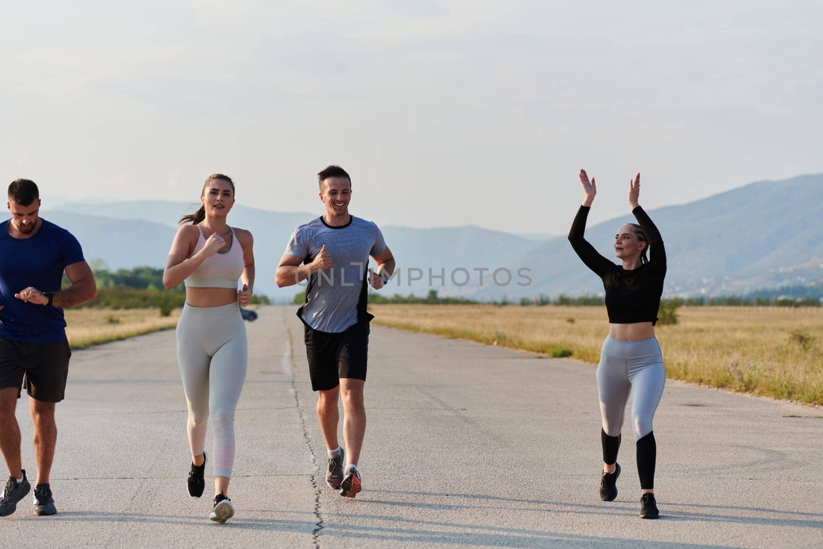 A group of friends maintains a healthy lifestyle by running outdoors on a sunny day, bonding over fitness and enjoying the energizing effects of exercise and nature by dotshock