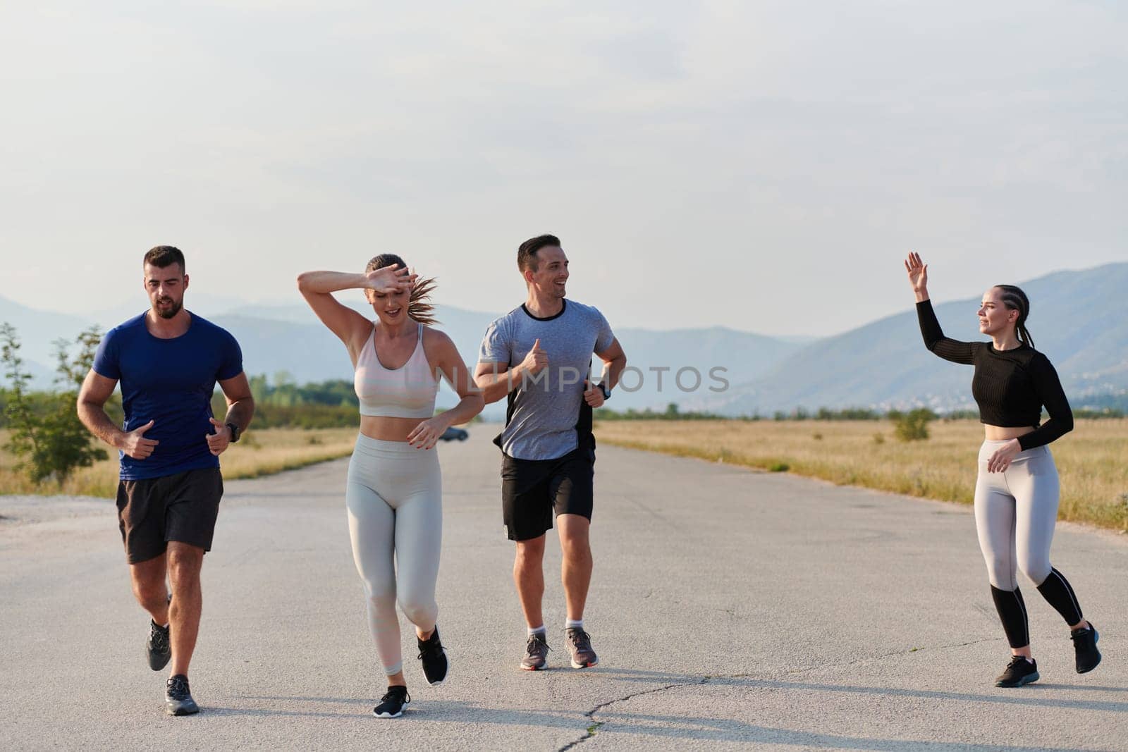 A group of friends maintains a healthy lifestyle by running outdoors on a sunny day, bonding over fitness and enjoying the energizing effects of exercise and nature by dotshock