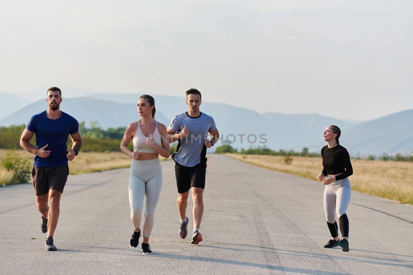 A group of friends maintains a healthy lifestyle by running outdoors on a sunny day, bonding over fitness and enjoying the energizing effects of exercise and nature by dotshock