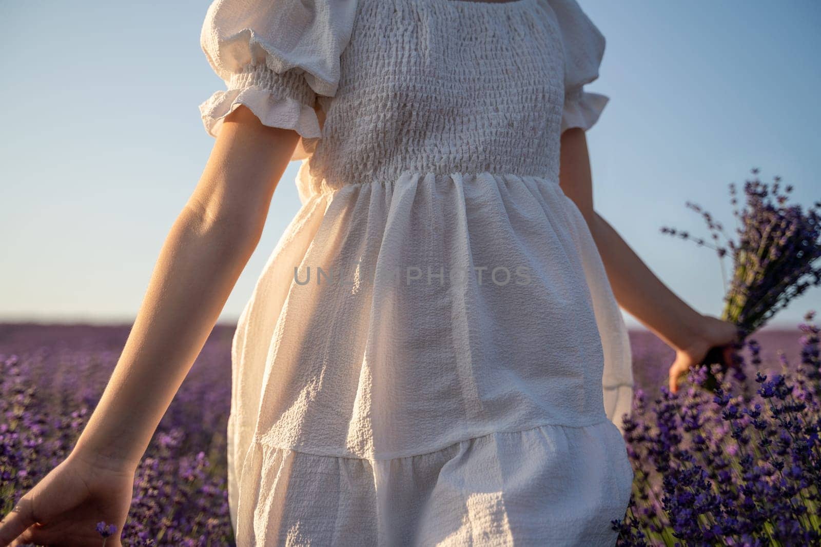 Lavender field happy girl in white dress with a scythe runs through a lilac field of lavender. Aromatherapy travel by Matiunina