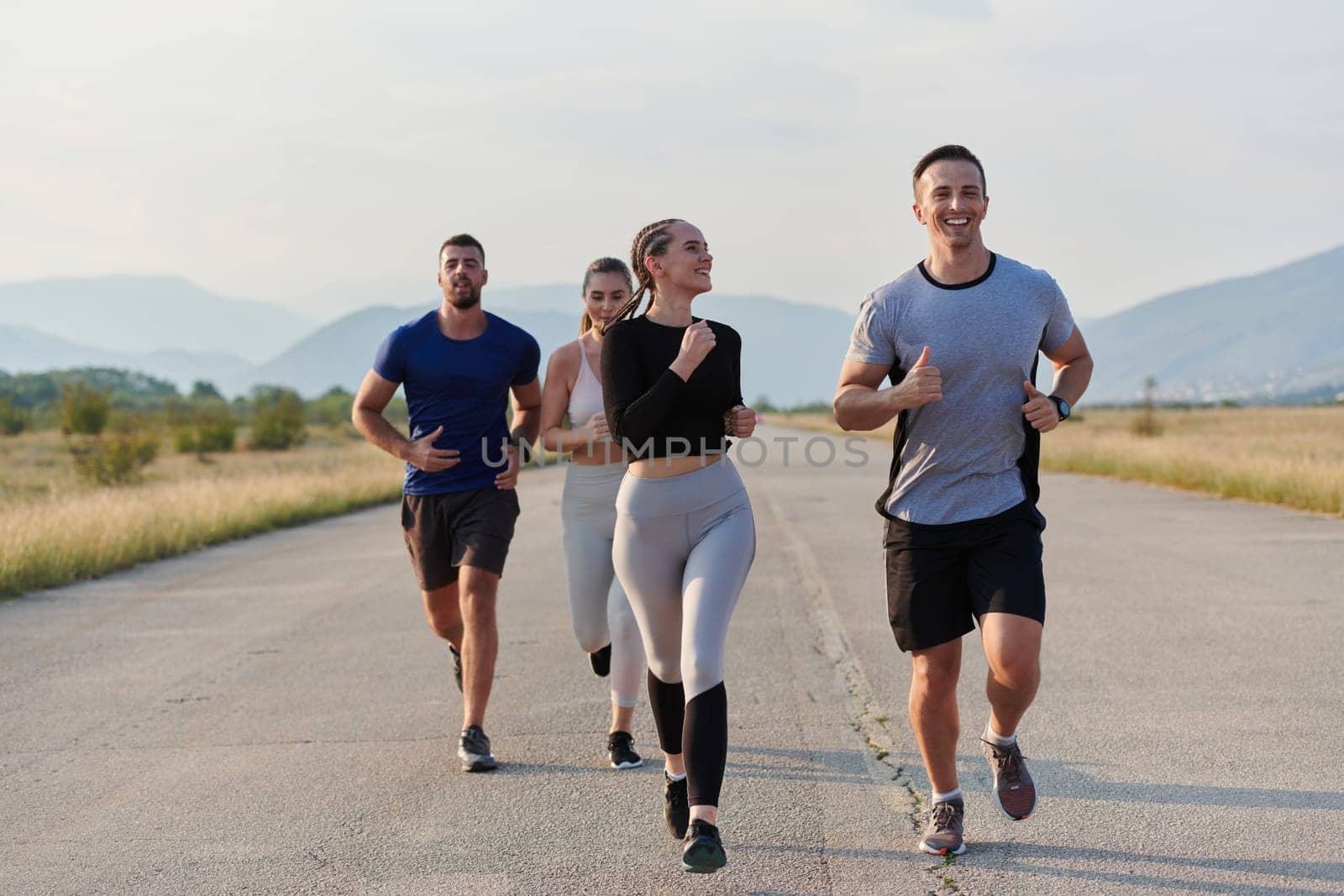 A group of friends maintains a healthy lifestyle by running outdoors on a sunny day, bonding over fitness and enjoying the energizing effects of exercise and nature.