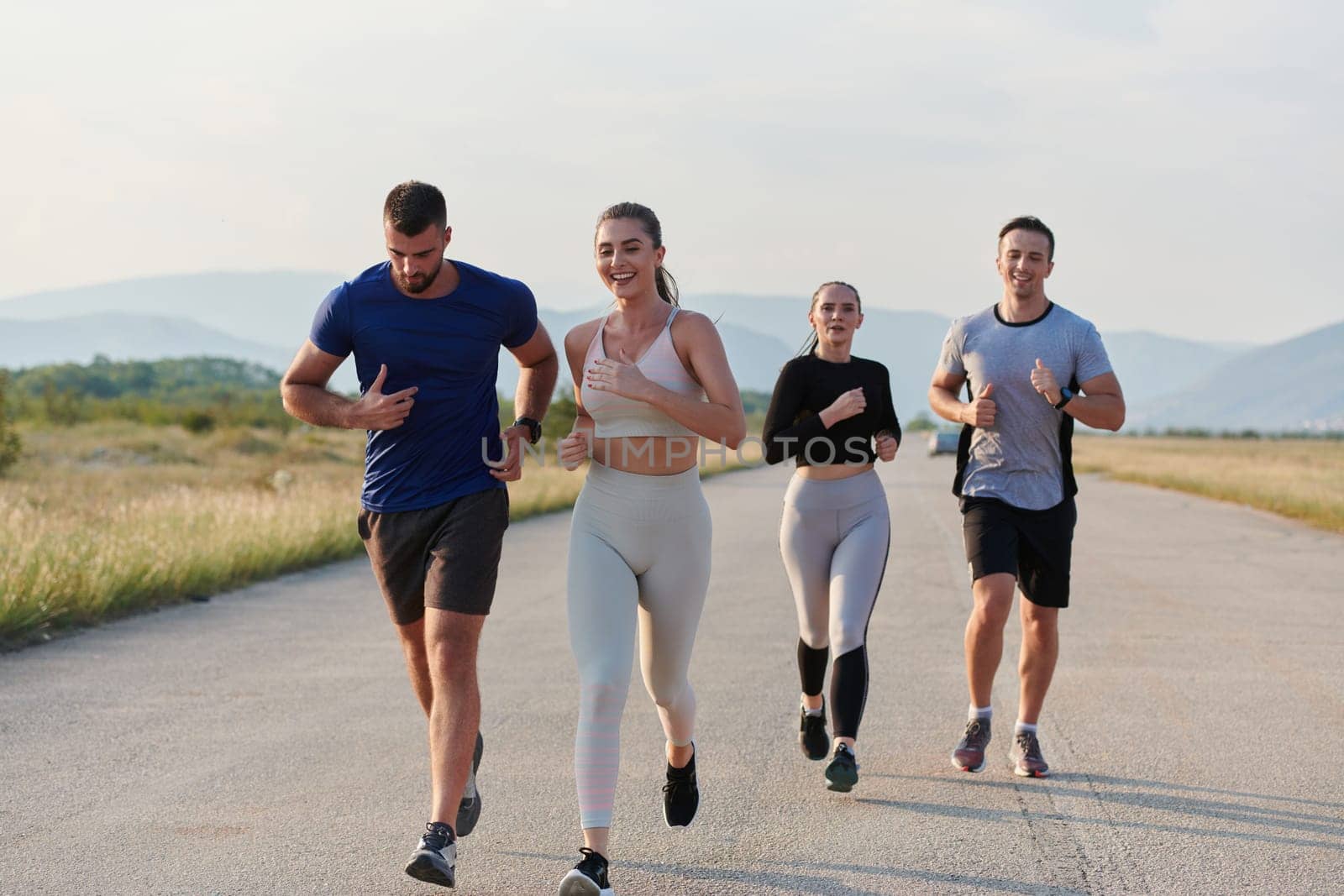 A group of friends maintains a healthy lifestyle by running outdoors on a sunny day, bonding over fitness and enjoying the energizing effects of exercise and nature by dotshock