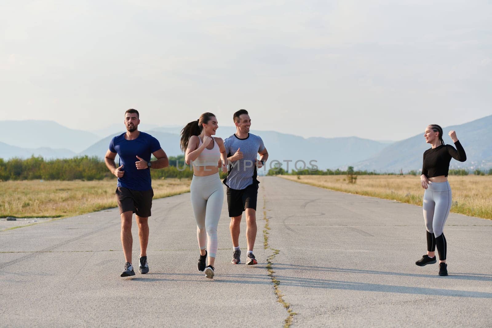 A group of friends maintains a healthy lifestyle by running outdoors on a sunny day, bonding over fitness and enjoying the energizing effects of exercise and nature by dotshock