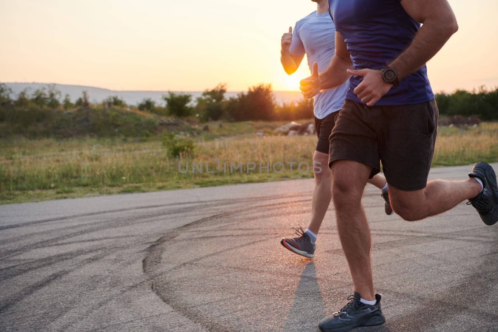 Marathon Partners: Two Athletic Friends Training Together for Upcoming Competition. by dotshock