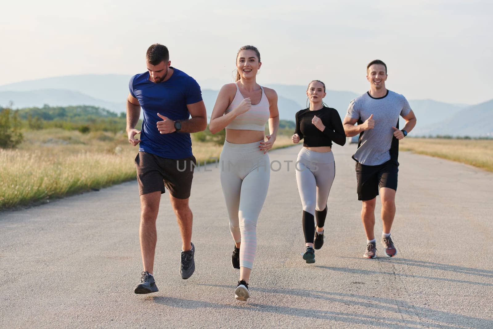 A group of friends maintains a healthy lifestyle by running outdoors on a sunny day, bonding over fitness and enjoying the energizing effects of exercise and nature by dotshock