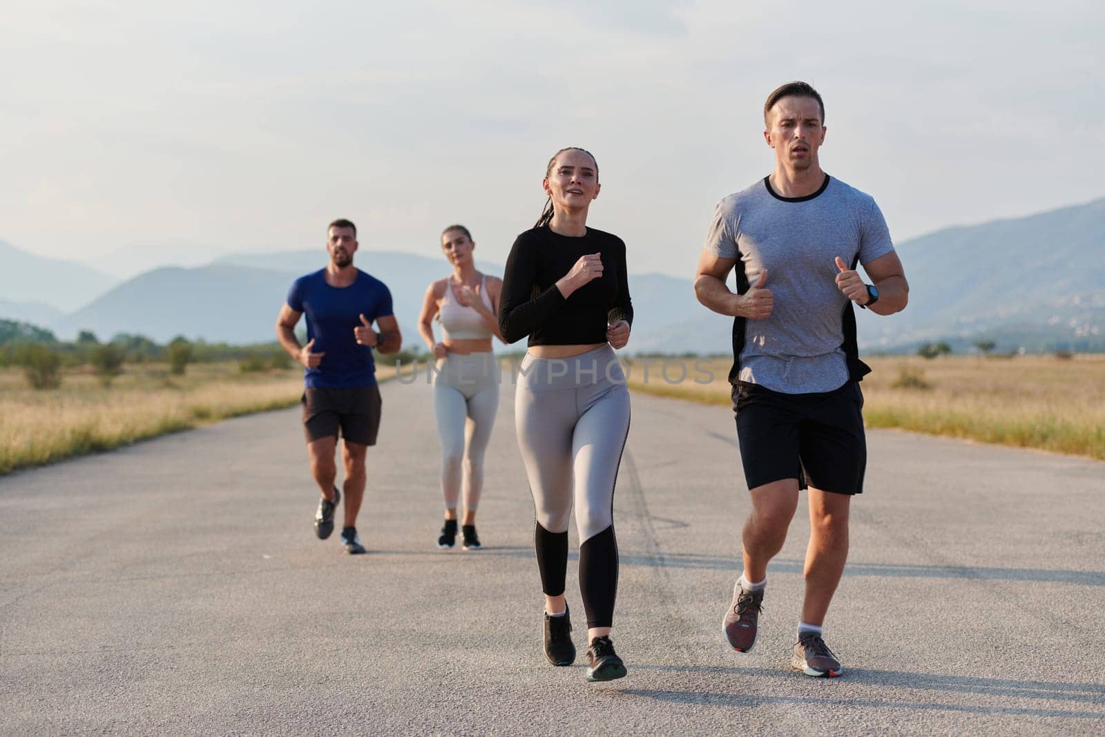 A group of friends maintains a healthy lifestyle by running outdoors on a sunny day, bonding over fitness and enjoying the energizing effects of exercise and nature.