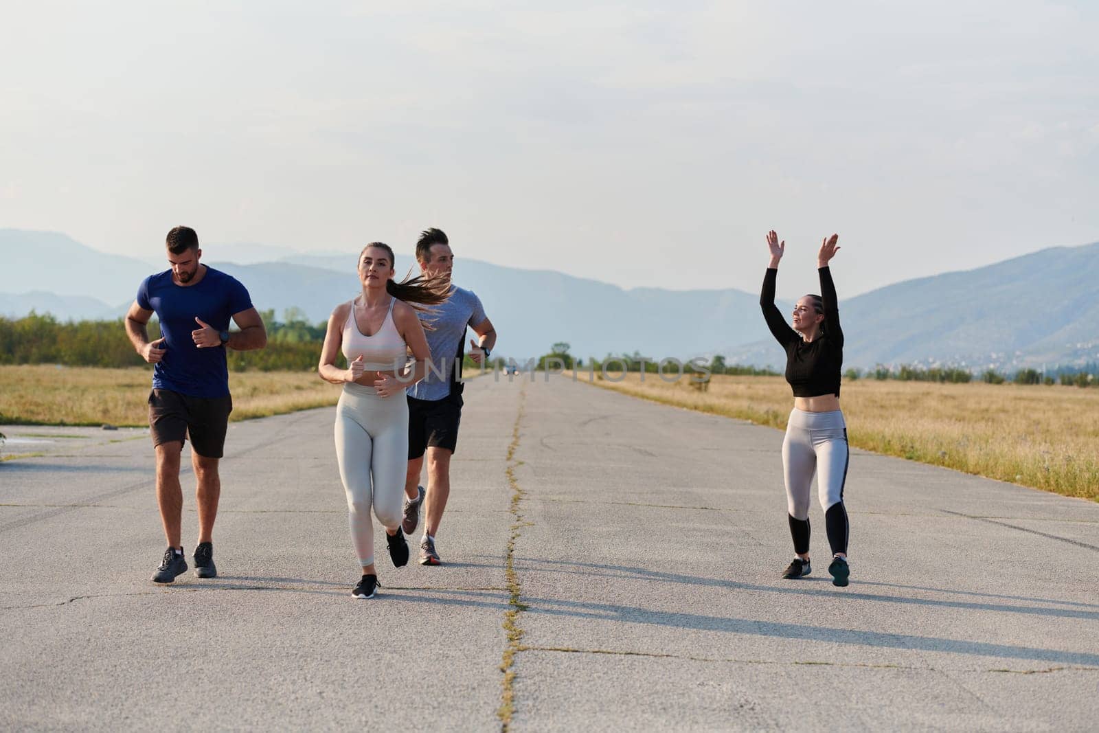 A group of friends maintains a healthy lifestyle by running outdoors on a sunny day, bonding over fitness and enjoying the energizing effects of exercise and nature by dotshock