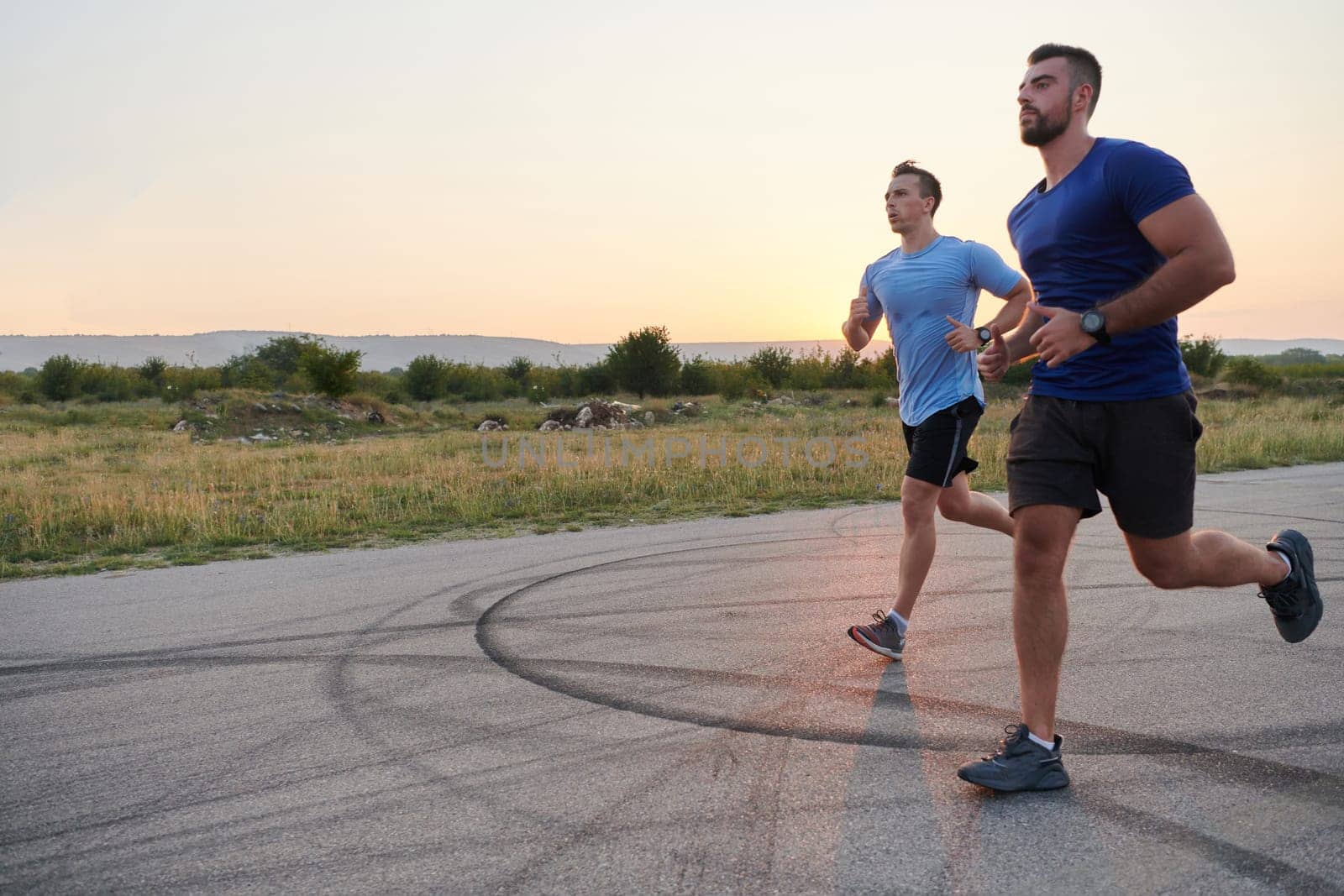 Marathon Partners: Two Athletic Friends Training Together for Upcoming Competition. by dotshock