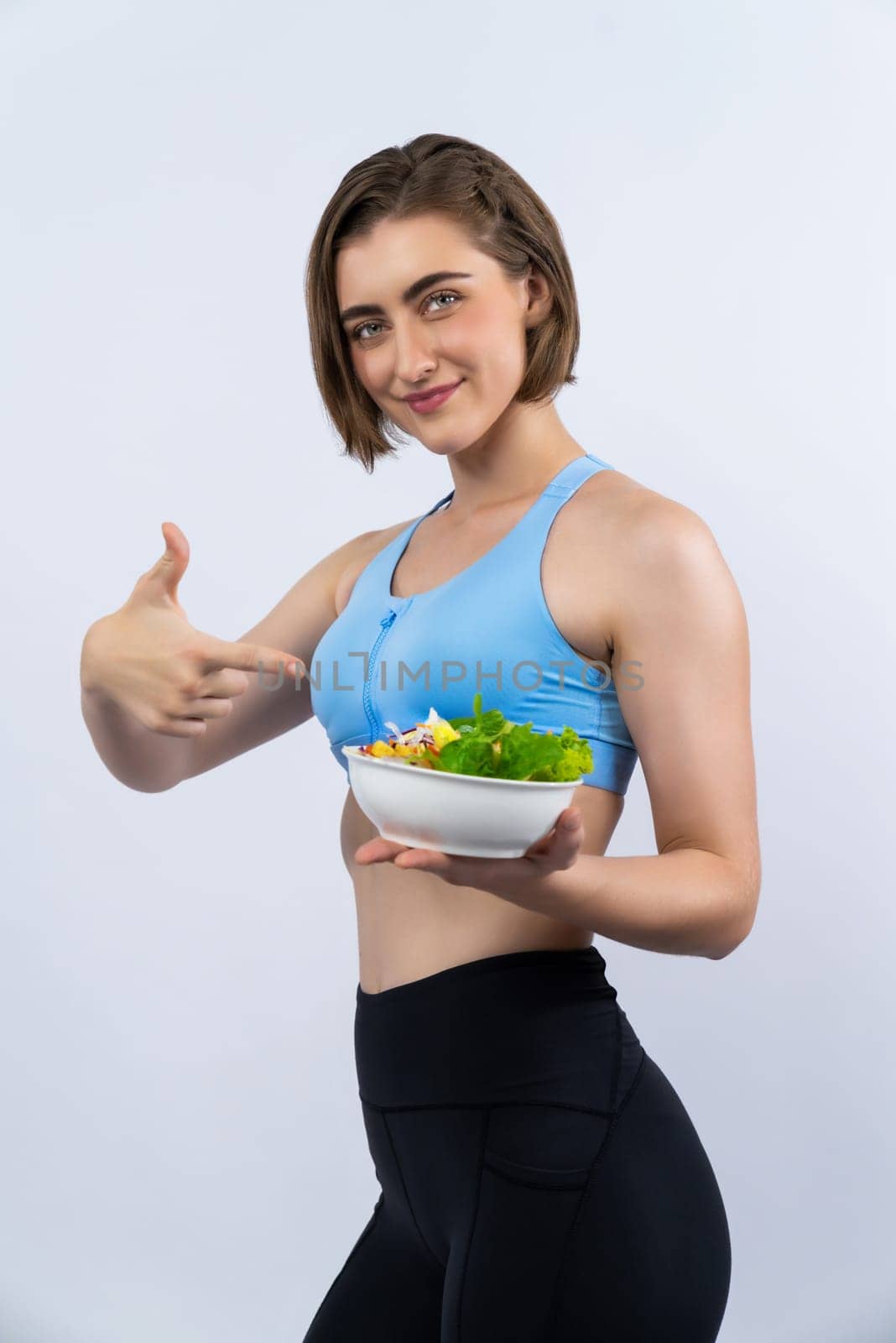 Full body length gaiety shot athletic and sporty young woman with healthy vegan food in standing posture on isolated background. Healthy active and body care by vegetarian lifestyle.