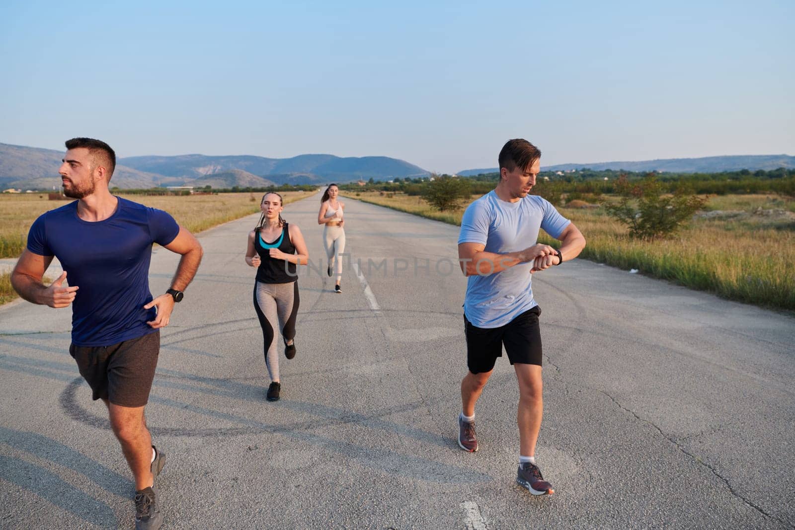 A group of friends maintains a healthy lifestyle by running outdoors on a sunny day, bonding over fitness and enjoying the energizing effects of exercise and nature by dotshock