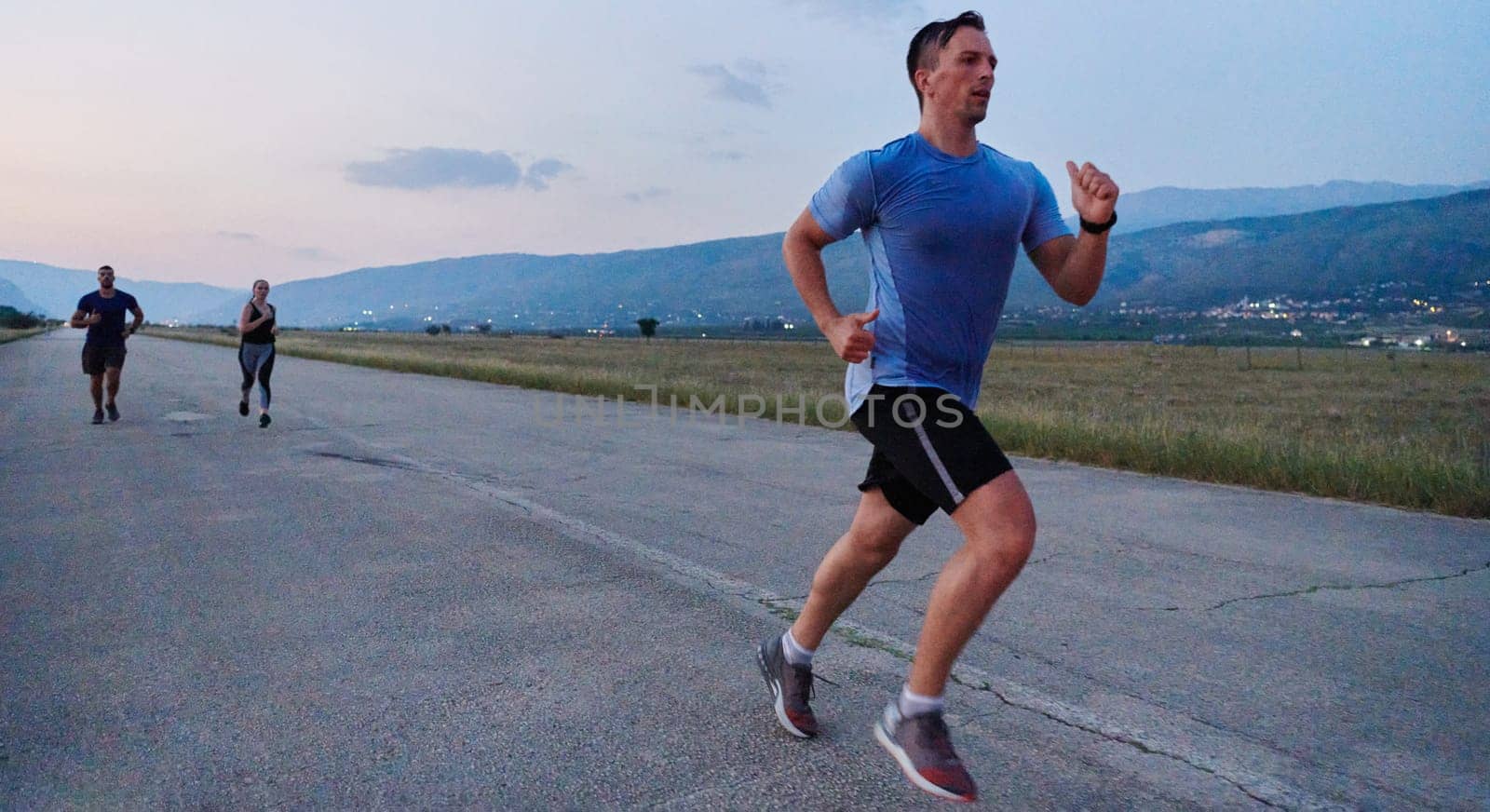 A group of friends maintains a healthy lifestyle by running outdoors on a sunny day, bonding over fitness and enjoying the energizing effects of exercise and nature by dotshock