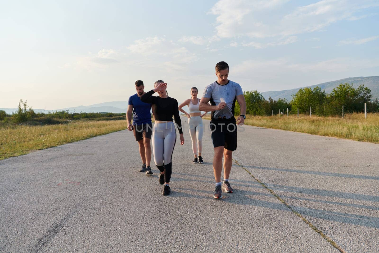 A group of friends maintains a healthy lifestyle by running outdoors on a sunny day, bonding over fitness and enjoying the energizing effects of exercise and nature by dotshock