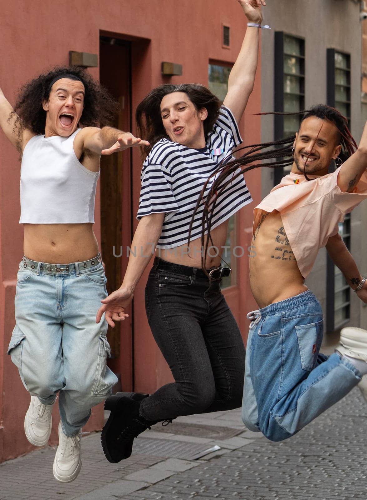 Three multuethnic gay people are excited together in Madrid city chueca street.