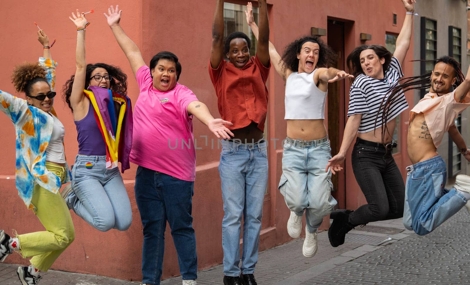 A large group of multuethnic gay people are excited together in Madrid city chueca street.