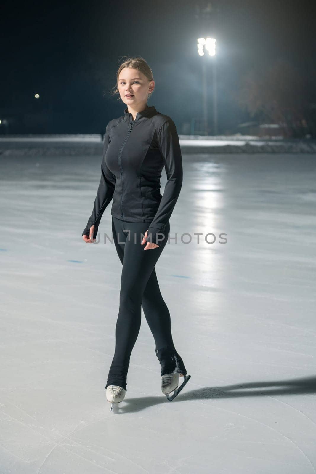 Beautiful young woman ice skating by rusak