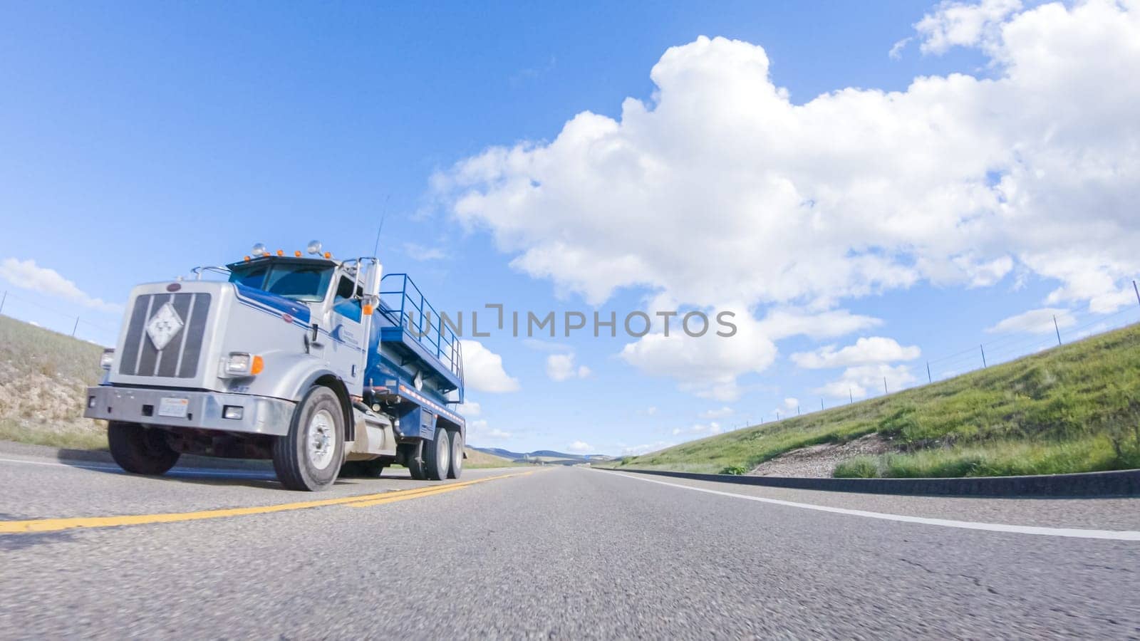 Santa Maria, California, USA-December 6, 2022-On a clear winter day, a car smoothly travels along Highway 101 near Santa Maria, California, under a brilliant blue sky, surrounded by a blend of greenery and golden hues.