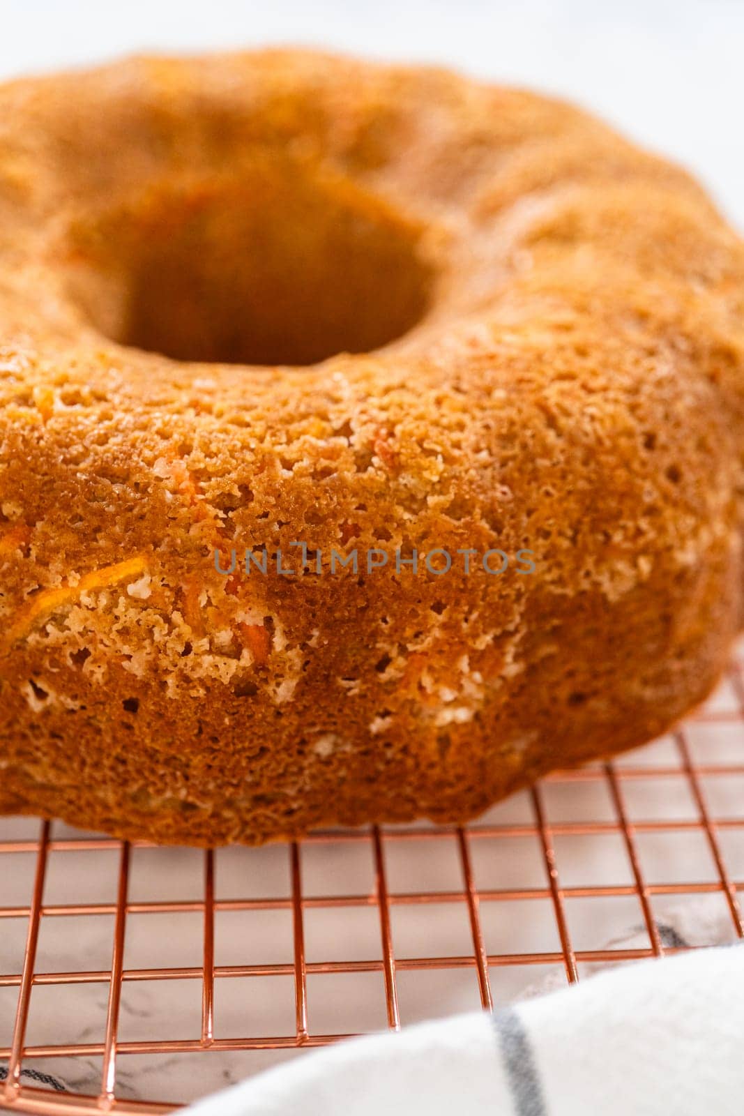 The freshly baked Carrot Bundt Cake is left to cool on the kitchen counter, filling the air with delightful aromas.