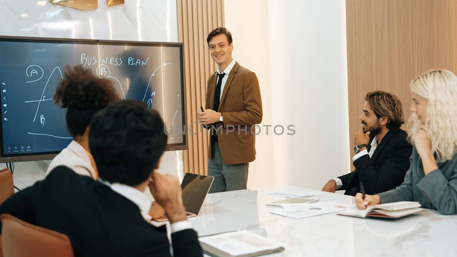 Presentation in ornamented meeting room with business professionals attending to project development drafting plan. Conference meeting with CEO present plan for investor and colleague with new project