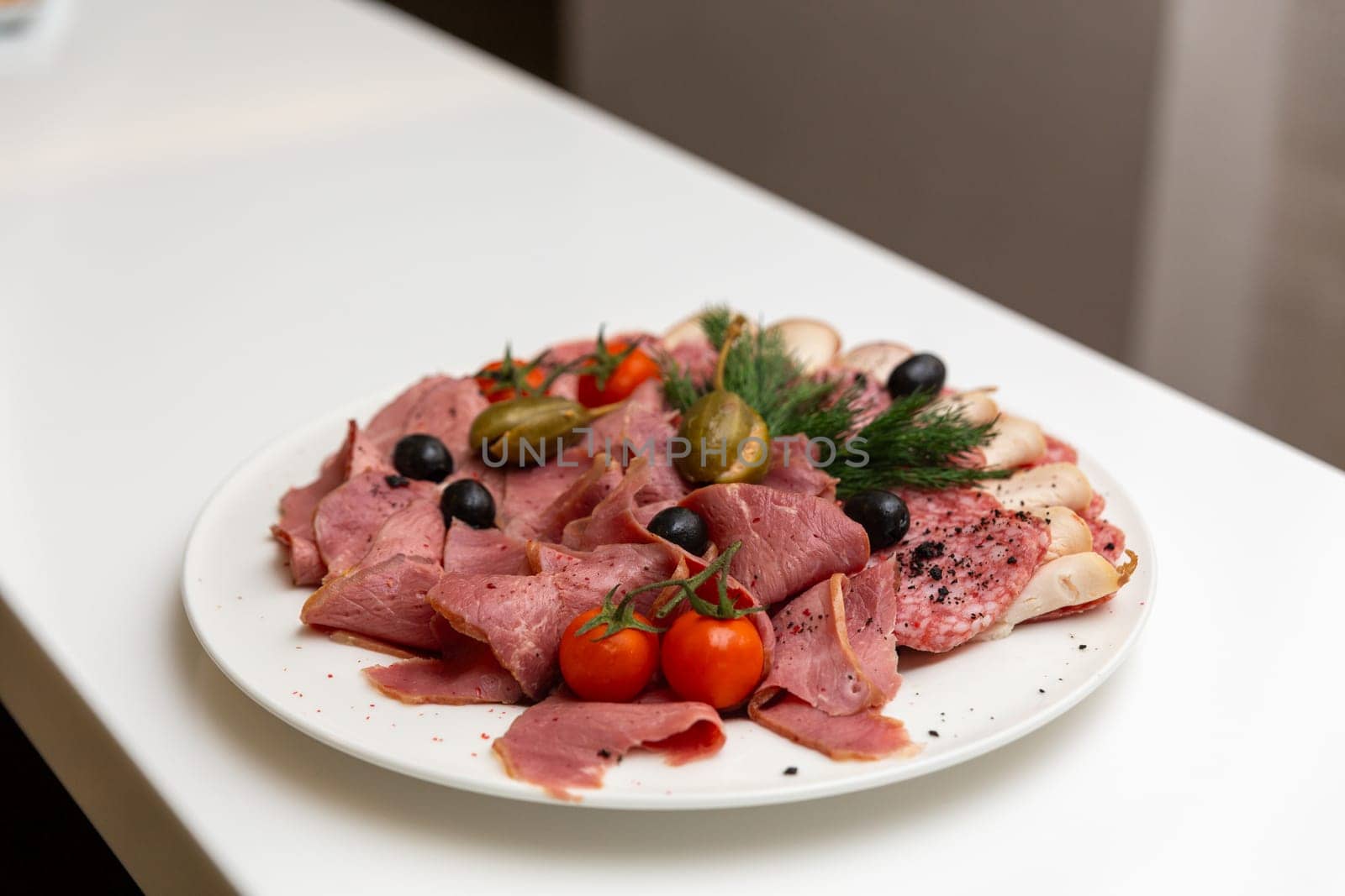 Meat delicatessen plate arranged with cherry tomato, black and green olives and capers. by BY-_-BY