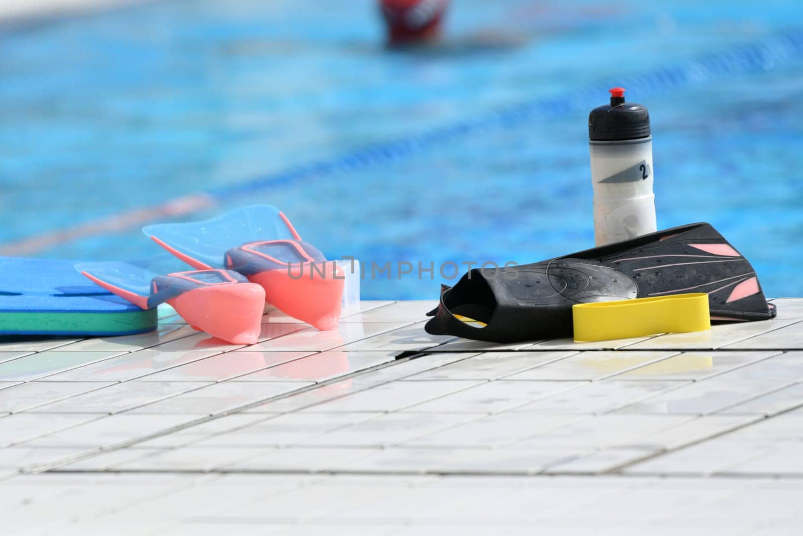 Fins and a bottle of water near the pool by Godi