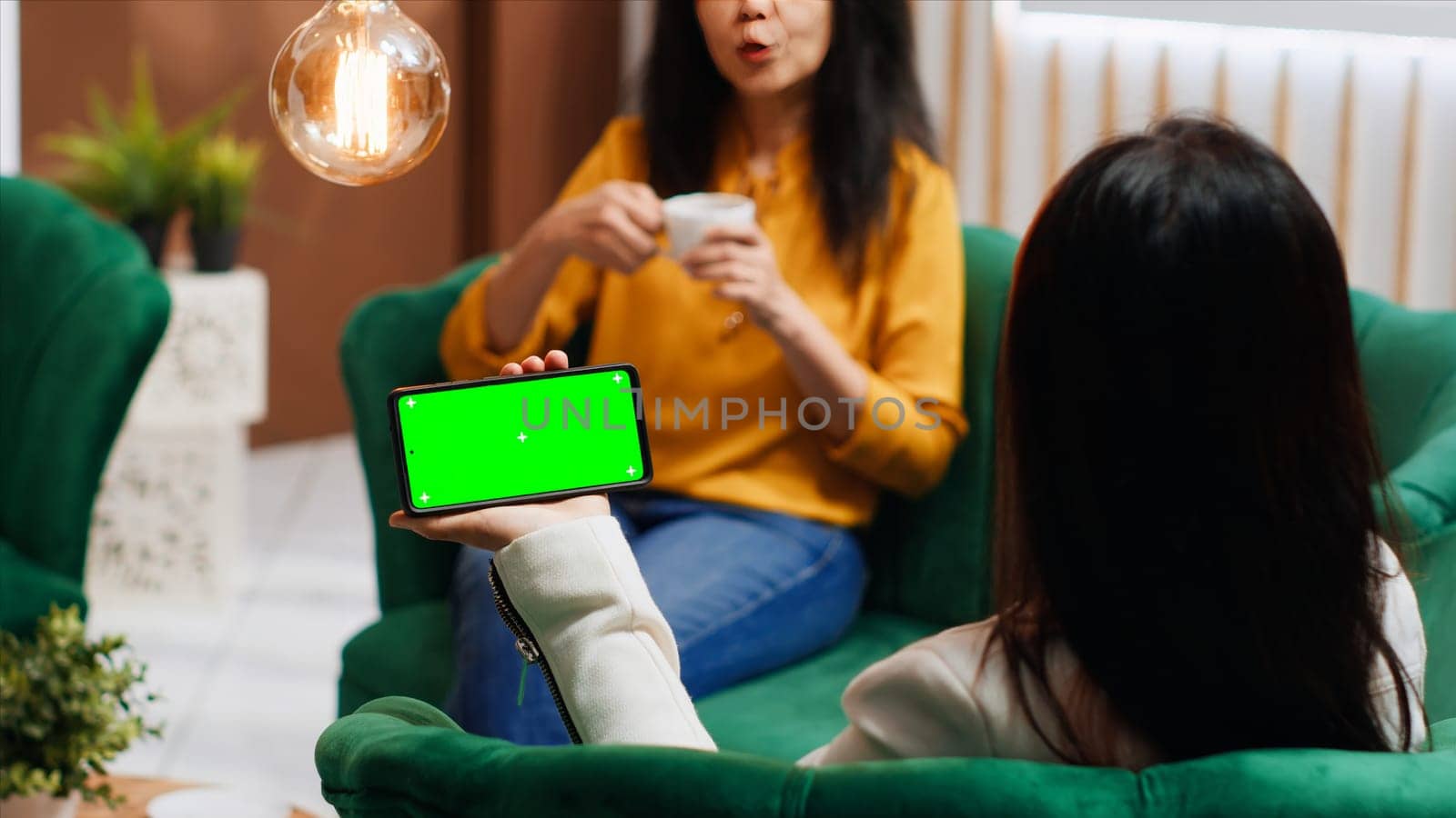 Asian traveler using smartphone with blank greenscreen at hotel by DCStudio