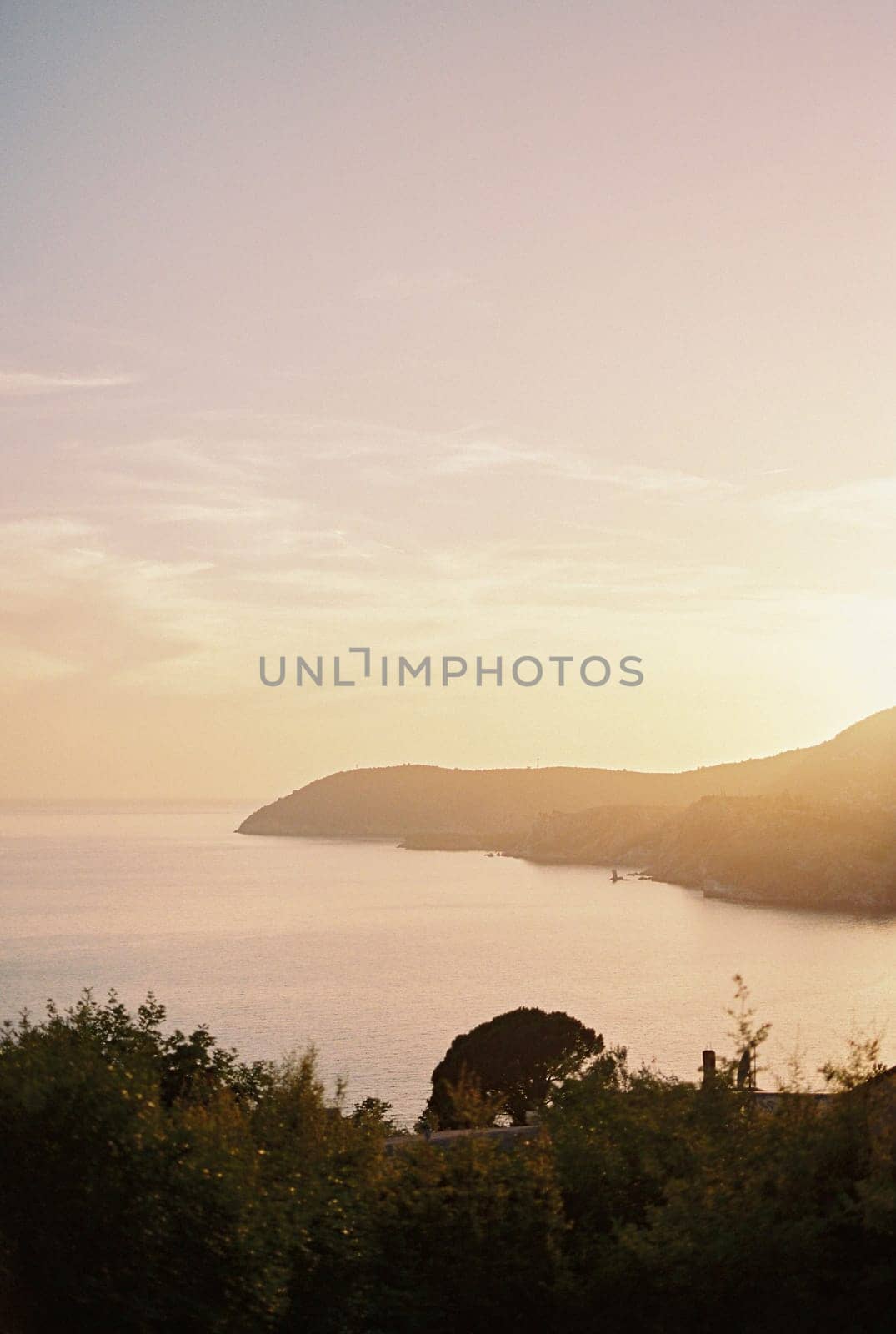 Pink sunset over the mountainous sea coast. High quality photo