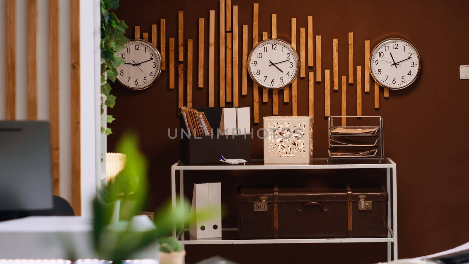 Empty front desk and lobby at luxurious vacation resort with clocks showing different international time zones. Modern reception and lounge area ready for guests and travelers, hospitality industry.