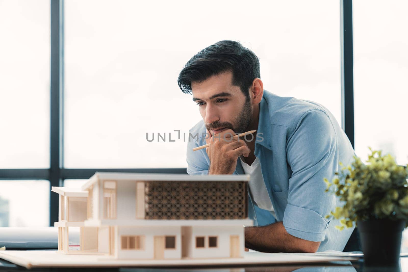 Smart civil architect engineer looking while planing design house construction with blueprint, house model and architectural equipment. Designer measuring and inspecting house model. Design. Tracery.