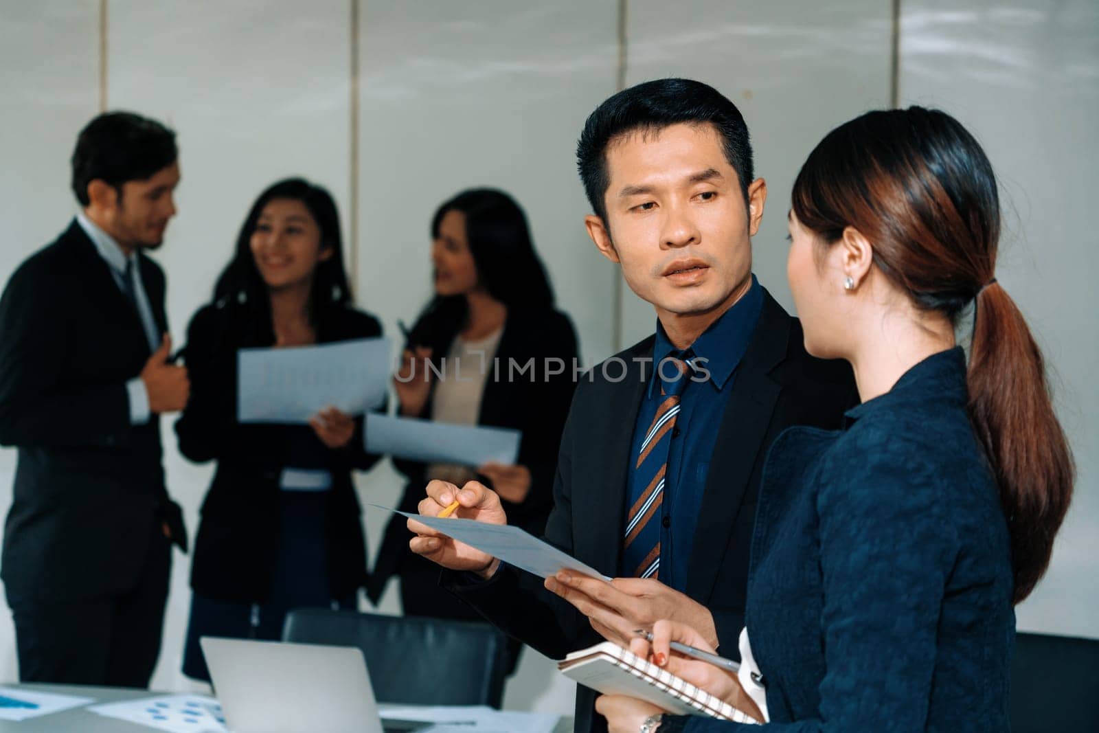 Businessman CEO talking to businesswoman secretary in the meeting room at international conference. Business concept. uds