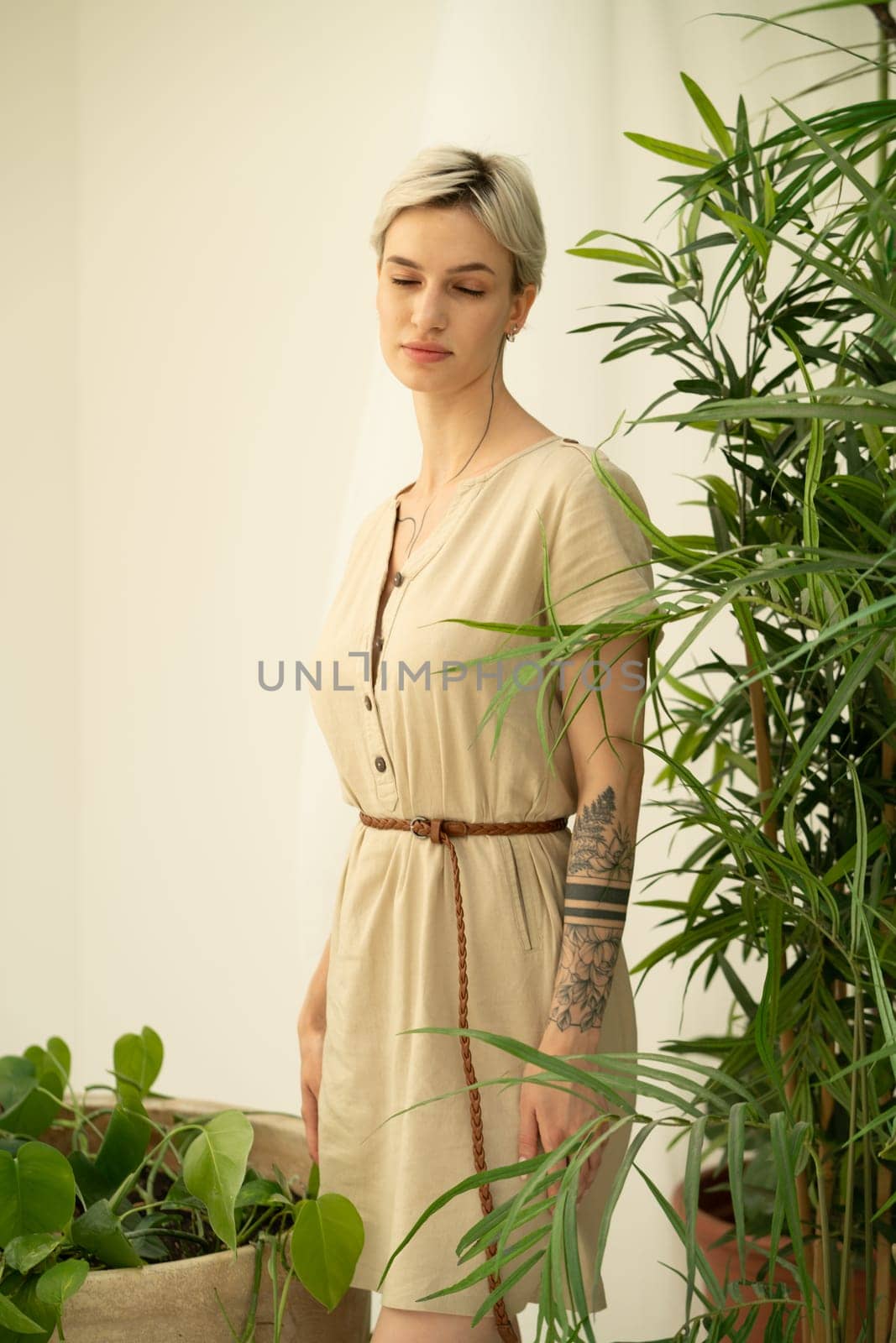 young beautiful woman posing in a beige dress in the studio