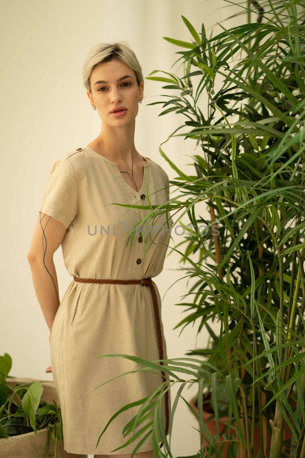 young beautiful woman posing in a beige dress in the studio