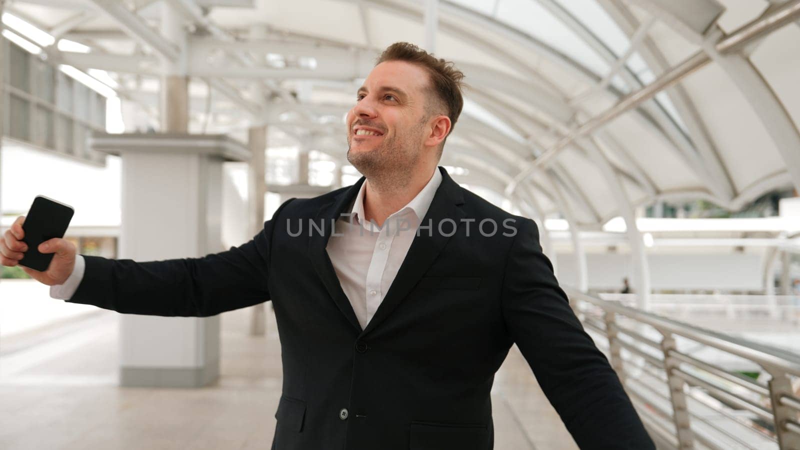 Businessman receive good news from his phone while walking at corridor. Urbane. by biancoblue