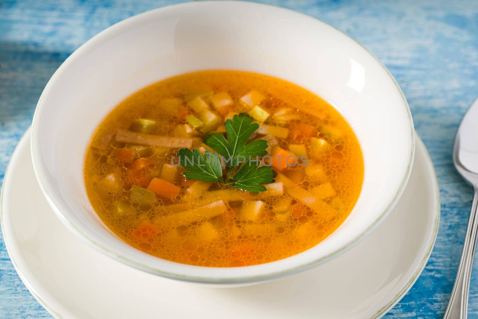Top view of healthy vegetable soup on white porcelain plate