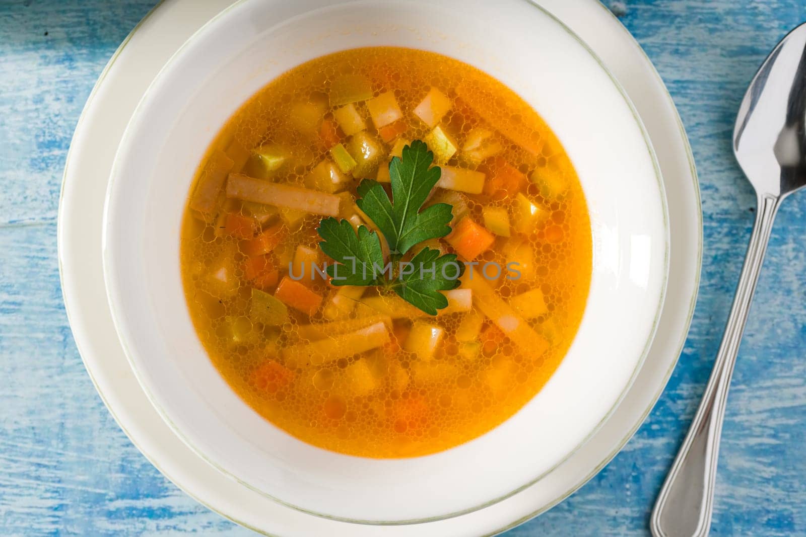 Top view of healthy vegetable soup on white porcelain plate by Sonat