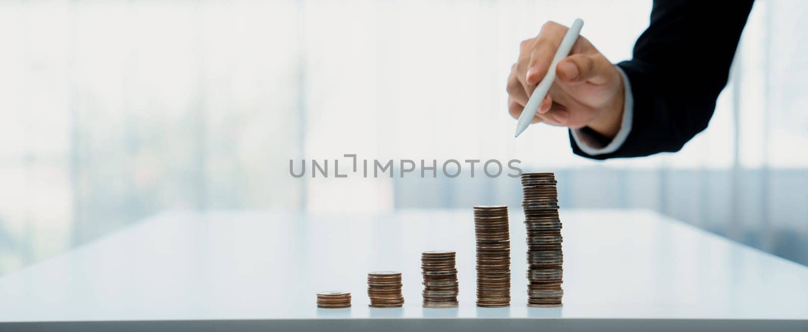 Growth coin stack symbolizing business investment and economic growth. Business people doing financial planning to achieve financial goal and contribute maximum profit gain . Shrewd