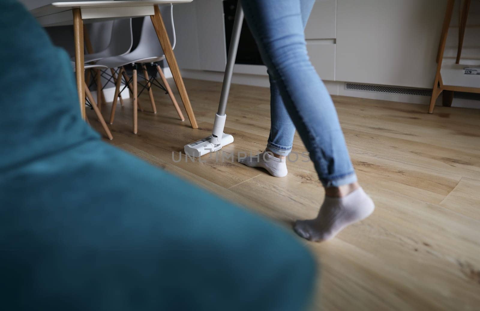 Woman cleaning floor in apartment with vacuum cleaner closeup. Cleaning services for apartments concept