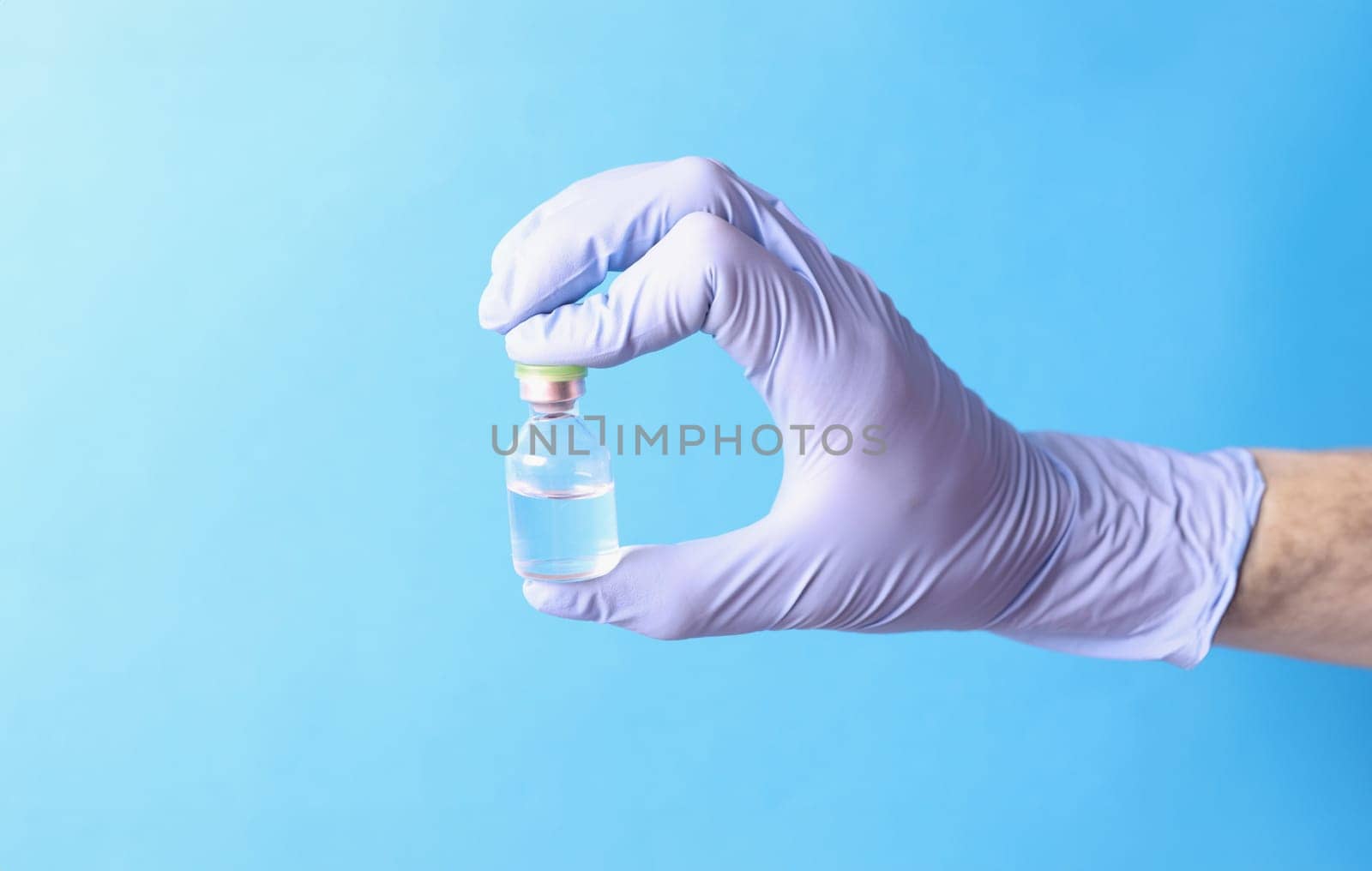 Doctor holding glass ampoule with medicine in rubber gloves closeup. Vaccination against covid 19 concept