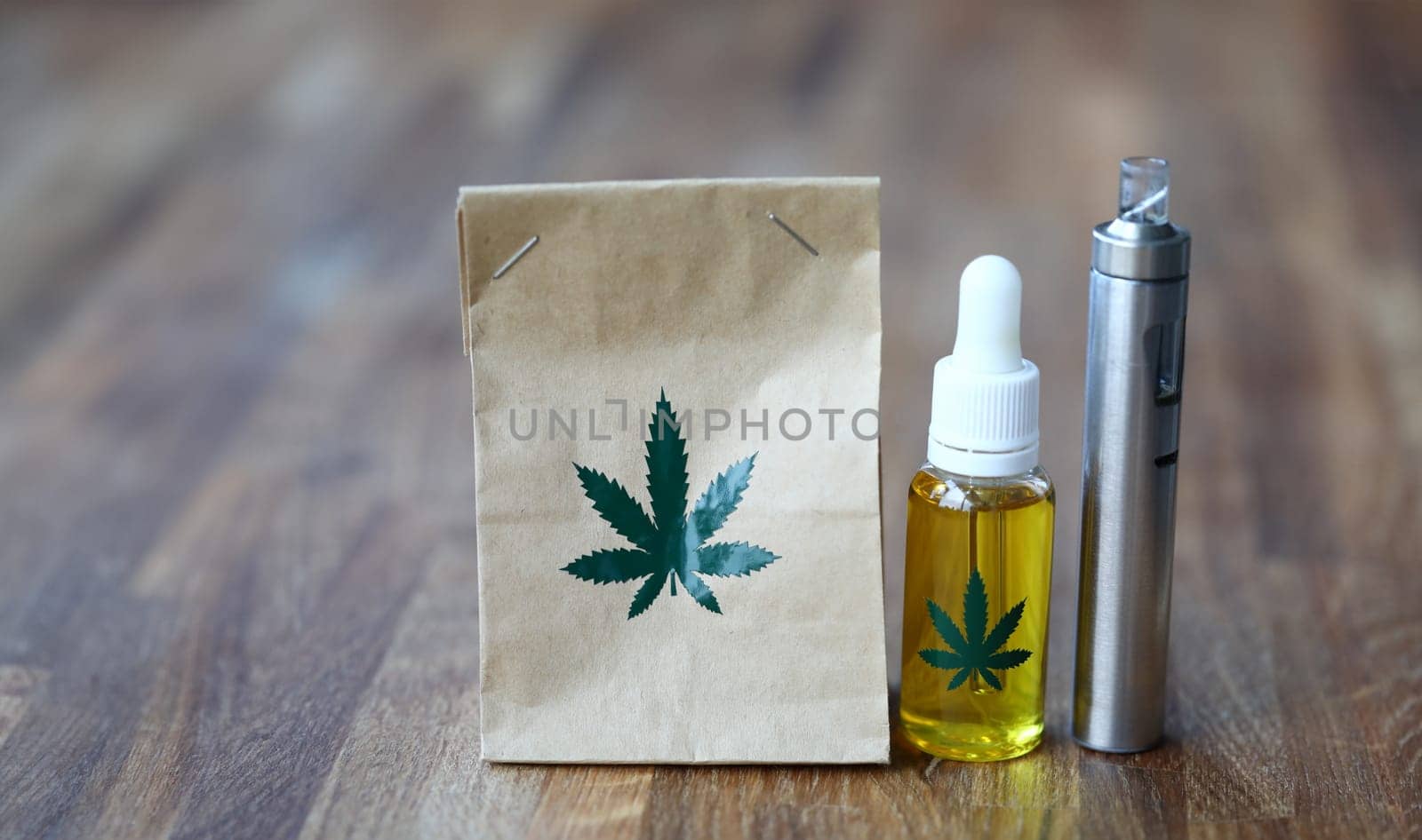 Paper organic bag with marijuana vaporizer cbd oil stand on a wooden table closeup