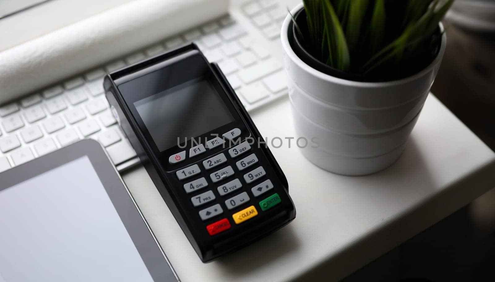 Mobile POS payment terminal lie on white table closeup background