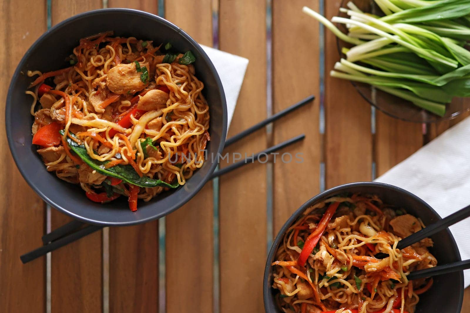 Stir-fry chicken with noodles, vegetables and herbs, with oyster and soy sauce. Asian style dish, top view.