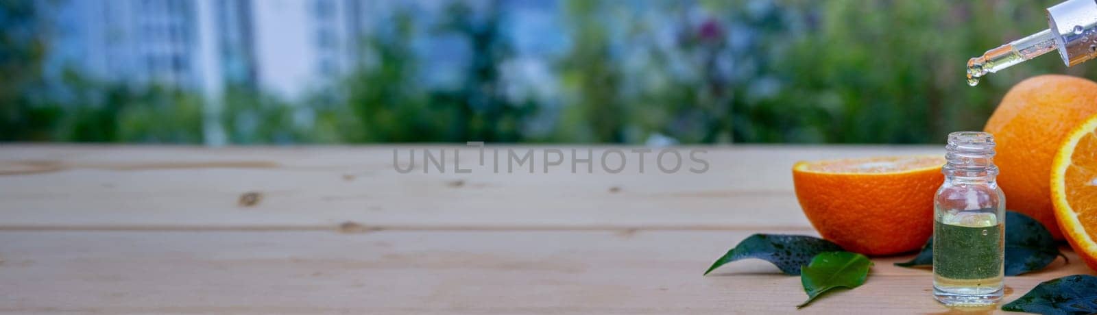 bottle of aromatic essence and fresh orange on the background of nature