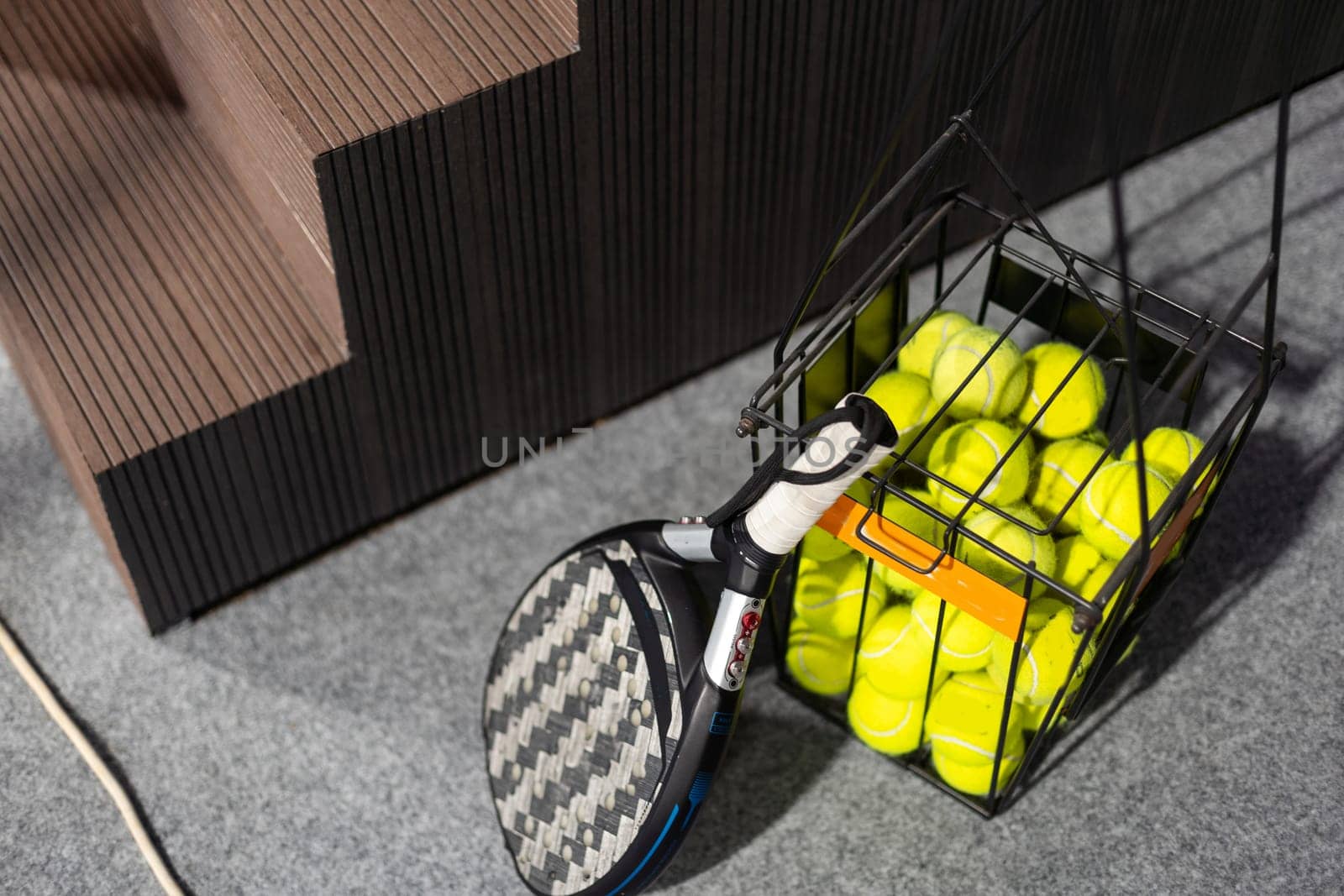 Closeup view of a paddle racket in a padel tennis court near the net. Sport, health, youth and leisure concept. Sporty equipment. White lines in background. High quality photo