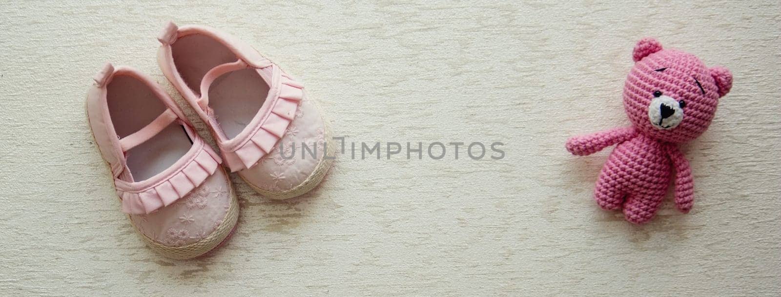 Children's shoes and teddy bear on a light background. Background with place for text.