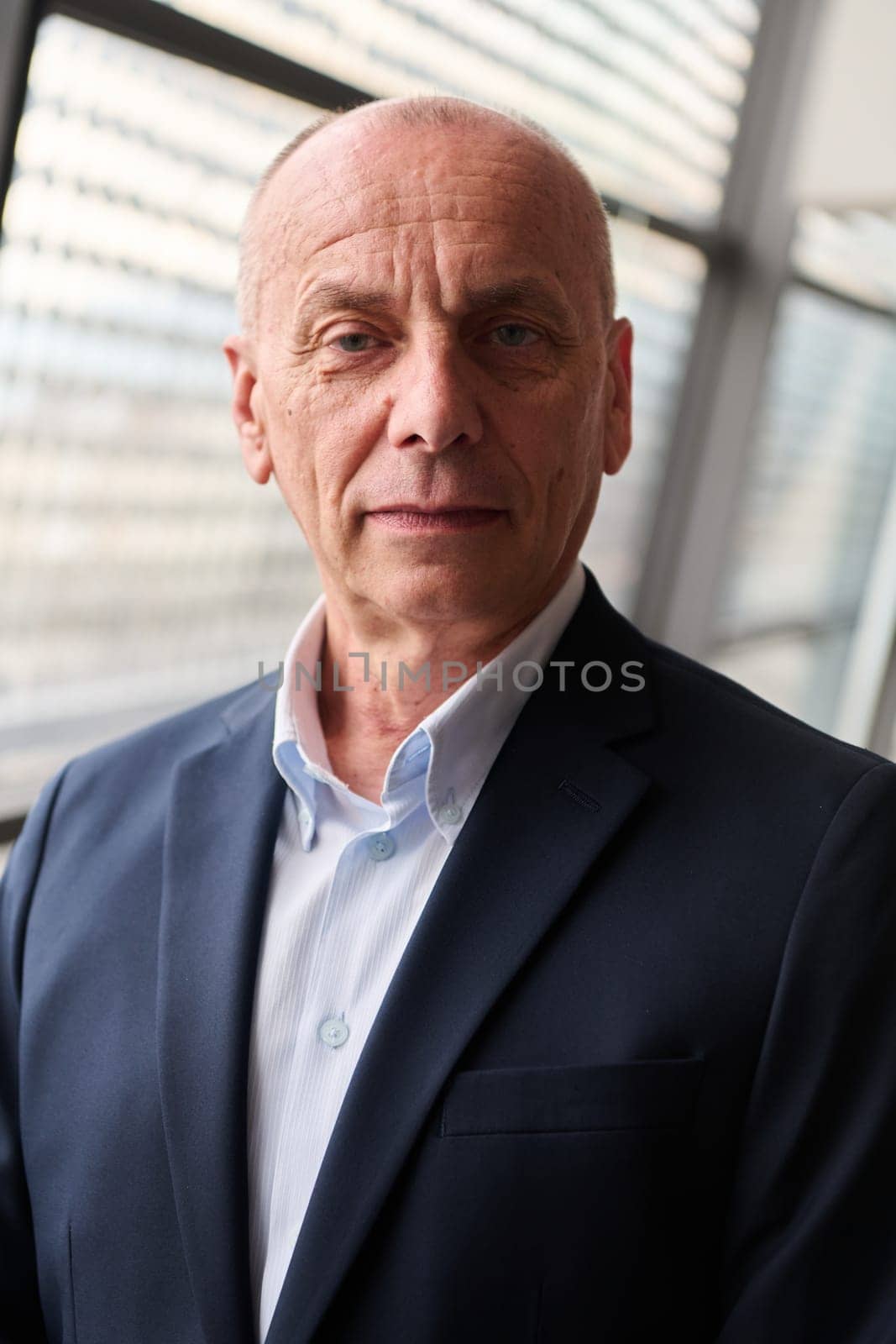 An older businessman exudes confidence in a contemporary conference room setting.